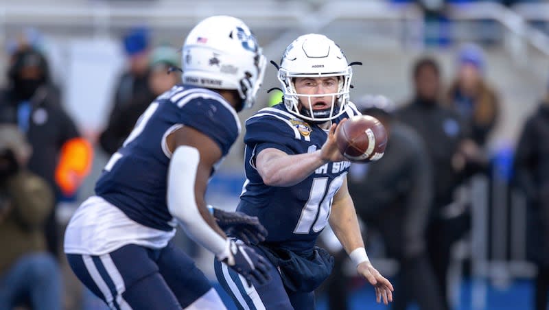 Utah State quarterback McCae Hillstead (10) pitches the ball to running back Robert Briggs Jr. (2) during the second half of the team's Famous Idaho Potato Bowl NCAA college football game against Georgia State, Saturday, Dec. 23, 2023, in Boise, Idaho.