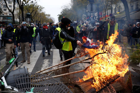 Protesters wearing yellow vests install a barricade during clashes with police at a demonstration during a national day of protest by the "yellow vests" movement in Paris, France, December 8, 2018. REUTERS/Stephane Mahe