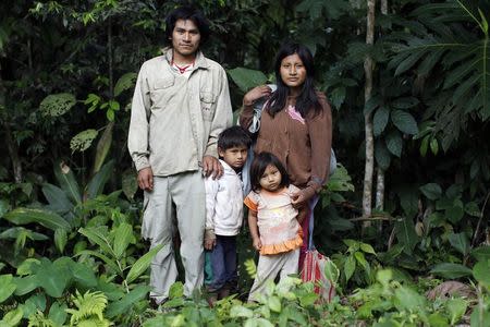 Machiguenga indigenous people Antonio Aguilar (L) and Jesica Araoz pose with their children Manuel and Betsabe close to their home in Shipetiari, a village near the Alto Madre de Dios River, May 25, 2014. REUTERS/Enrique Castro-Mendivil