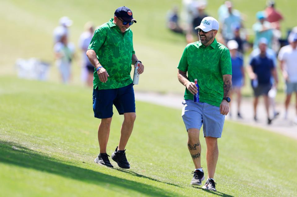 J.C. Cerveny, left, and Rich Albano enjoy a beer and laugh while walking adjacent to hole 18 of the Players Stadium Course at TPC Sawgrass during the final round of The Players Championship on Sunday.