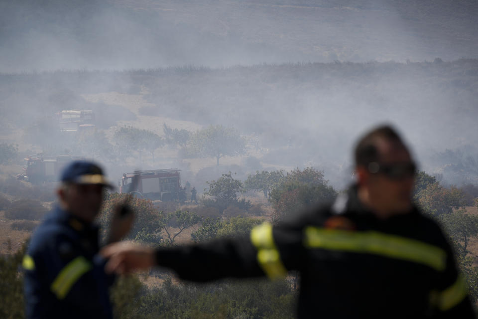 Firefighters work to extinguish a forest fire around Marathon town, northeast of Athens, on Saturday, Aug. 10, 2019. Firefighters fight against a fire at the city of Marathon, as a heatwave that has gripped most of Greece, combined with persistent high winds, has helped ignite dozens of fires. (AP Photo/Thanassis Stavrakis)