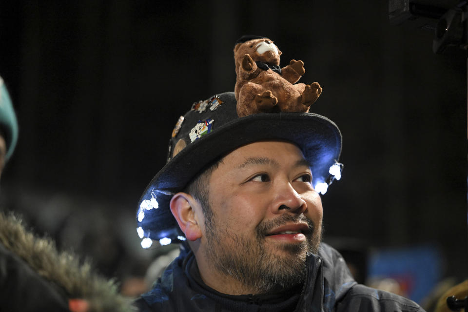 Alex Domingo of New Orleans watches the festivities while waiting for Punxsutawney Phil, the weather prognosticating groundhog, during the 137th celebration of Groundhog Day on Gobbler's Knob in Punxsutawney, Pa., Thursday, Feb. 2, 2023. Phil's handlers said that the groundhog has forecast six more weeks of winter. (AP Photo/Barry Reeger)