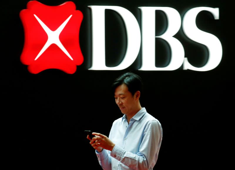 FILE PHOTO: A man walks past DBS signage in Singapore