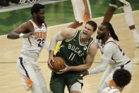 Milwaukee Bucks' Brook Lopez (11) is fouled as he drives between Phoenix Suns' Jae Crowder (99) and Deandre Ayton (22) during the second half of Game 3 of basketball's NBA Finals, Sunday, July 11, 2021, in Milwaukee. (AP Photo/Aaron Gash)