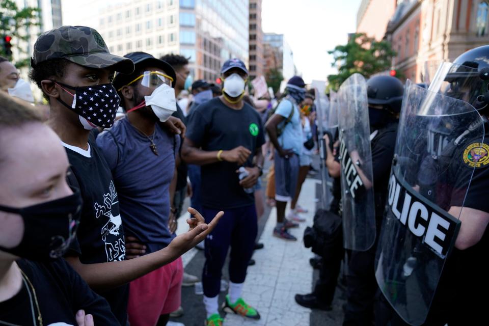 Authorities look on as demonstrators protest the death of George Floyd, Saturday, May 30, 2020, near the White House in Washington. Floyd died after being restrained by Minneapolis police officers.