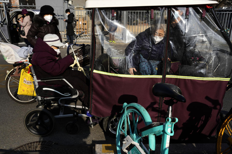 Elderly residents wear masks as they visit a hospital in Beijing, Friday, Dec. 9, 2022. China began implementing a more relaxed version of its strict "zero COVID" policy on Thursday amid steps to restore normal life, but also trepidation over a possible broader outbreak once controls are eased. (AP Photo/Ng Han Guan)