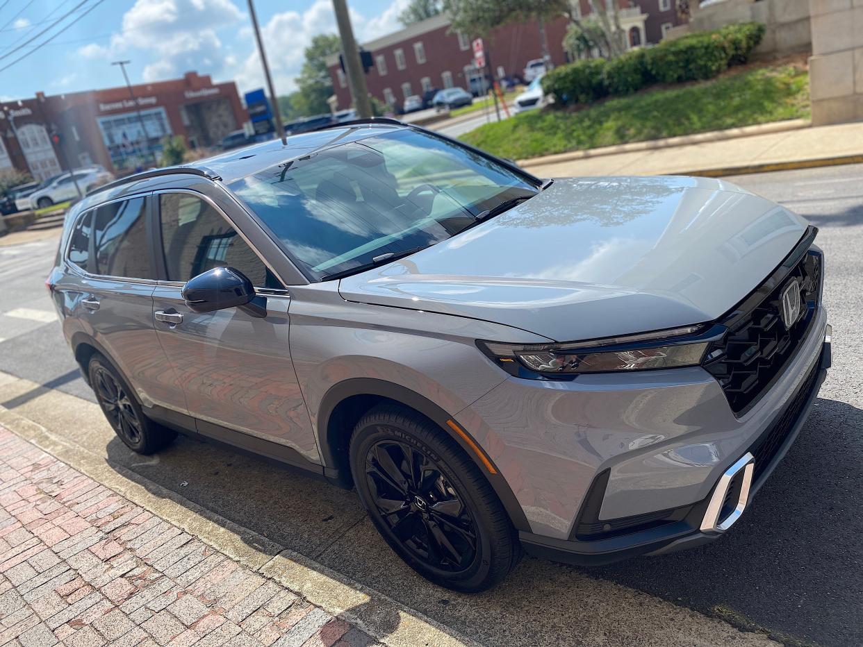 The right side of a gray 2025 Honda CR-V Hybrid SUV parked on a street.