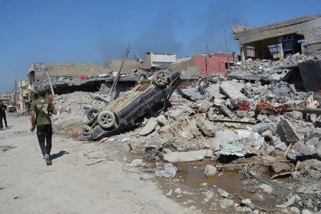 A destroyed car is seen at the site after an air strike attack against Islamic State triggered a massive explosion in Mosul, Iraq March 27, 2017. REUTERS/Stringer