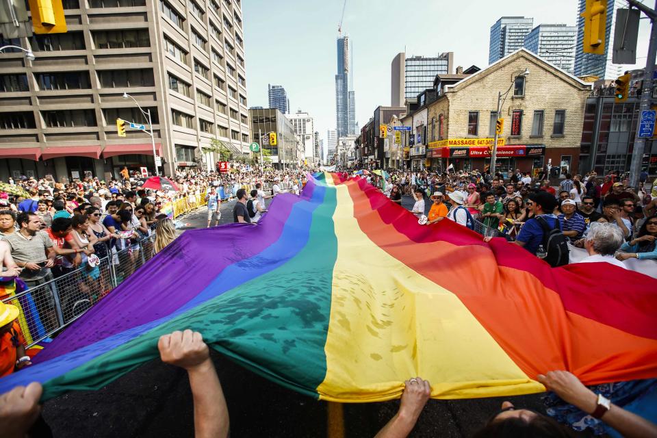 Revellers hold a giant pride flag during the "WorldPride" gay pride Parade in Toronto, June 29, 2014. Toronto is hosting WorldPride, a week-long event that celebrates the lesbian, gay, bisexual and transgender (LGBT) community. REUTERS/Mark Blinch (CANADA - Tags: SOCIETY)