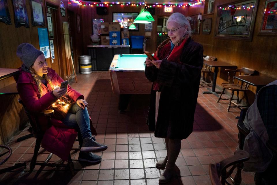 Angela Haban, 34, of Hamtramck and a campaign volunteer for Hamtramck city council candidate Amanda Jaczkowski sits at left as Hamtramck Mayor Karen Majewski checks in on election results during a stop at Whiskey In the Jar in Hamtramck on Nov. 2, 2021.