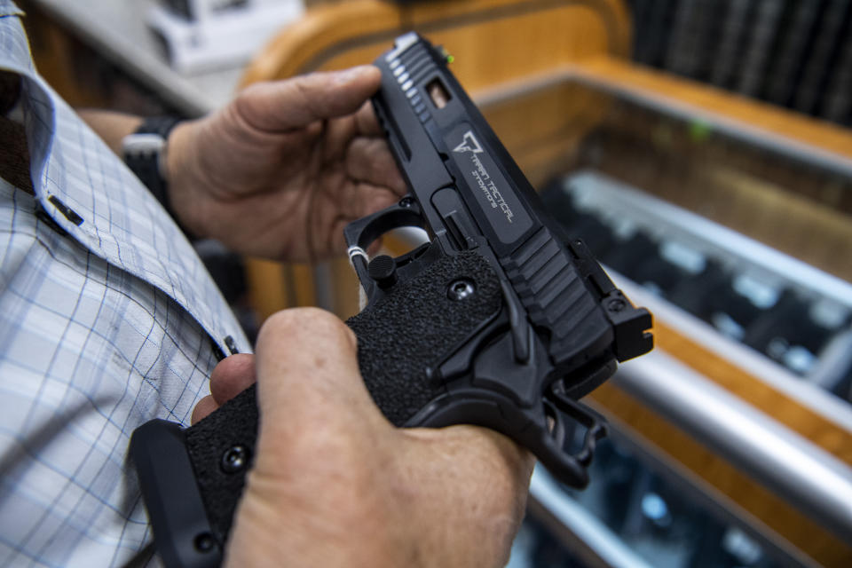 FILE - A customer checks out a hand gun that is for sale and on display at SP firearms on June 23, 2022, in Hempstead, New York. New York can continue to enforce laws banning firearms in sensitive locations, a federal appeals court ruled Friday, Dec. 8, 2023 in its first broad review of a host of new gun rules passed in the state after a landmark Supreme Court ruling last year.(AP Photo/Brittainy Newman, File)