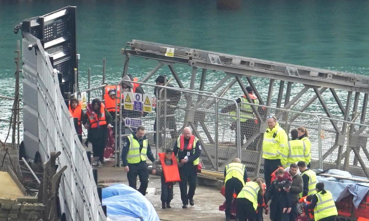 <span>A group of people arriving in Dover, Kent, in a small boat are helped to disembark a Border Force vessel on 4 March.</span><span>Photograph: Gareth Fuller/PA</span>