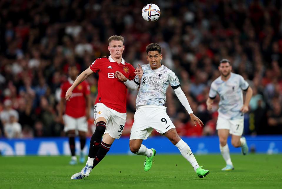 MANCHESTER, ENGLAND - AUGUST 22: Roberto Firmino of Liverpool is challenged by Scott McTominay of Manchester United during the Premier League match between Manchester United and Liverpool FC at Old Trafford on August 22, 2022 in Manchester, England. (Photo by Clive Brunskill/Getty Images)