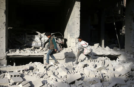 Boys walk on the rubble of damaged buildings after an airstrike in the besieged town of Douma, Eastern Ghouta, Damascus, Syria February 9, 2018. REUTERS/Bassam Khabieh