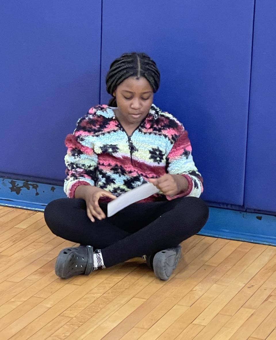 A Potter Road Elementary School student reads a prepared question for Daily News sports writer Tim Dumas on March 22, 2024.