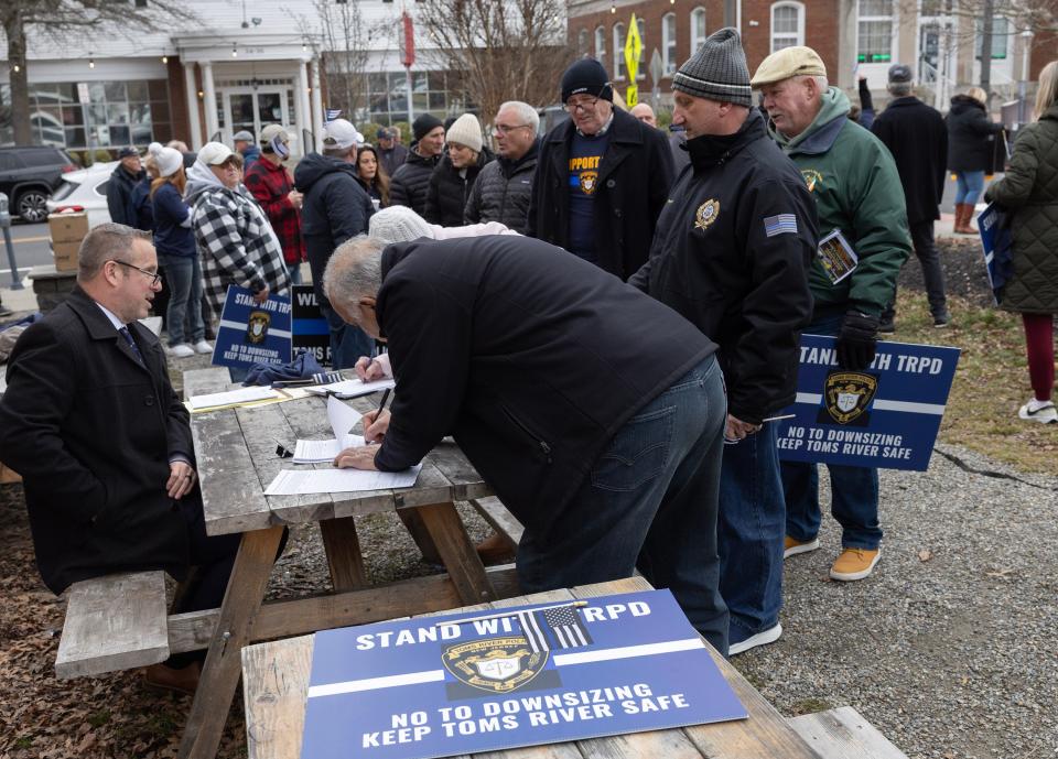 Those attending a Jan. 31, 2024, rally line up to sign the petition against the Toms River Township Council eliminating two police captain jobs. Between 80 and 90 people came out to protest the cuts.