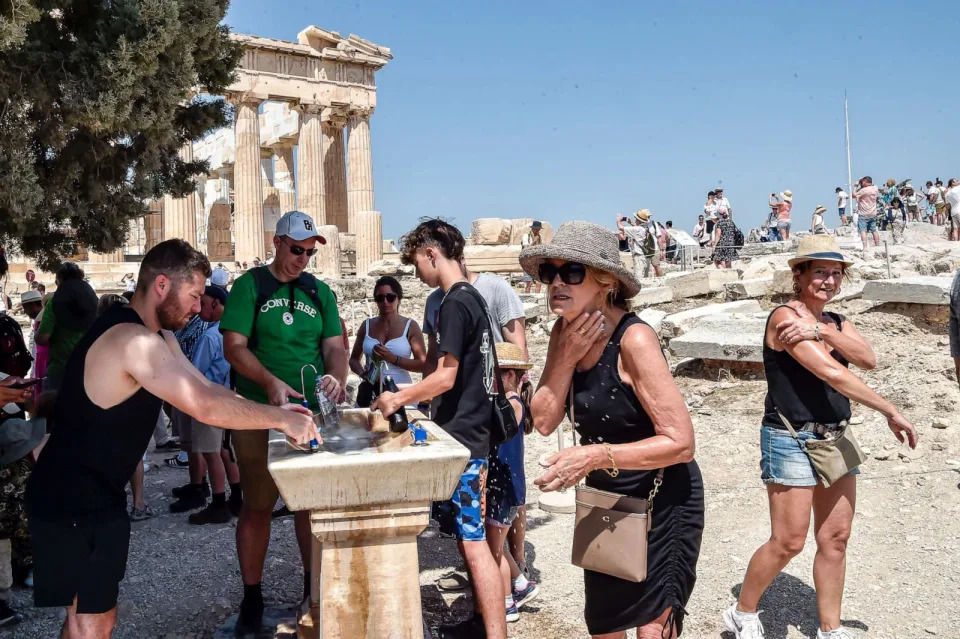 PHOTO: Tourists refresh with water near the Parthenon temple at the Acropolis hill during a heat wave on July 20, 2023 in Athens, Greece. (Milos Bicanski/Getty Images)