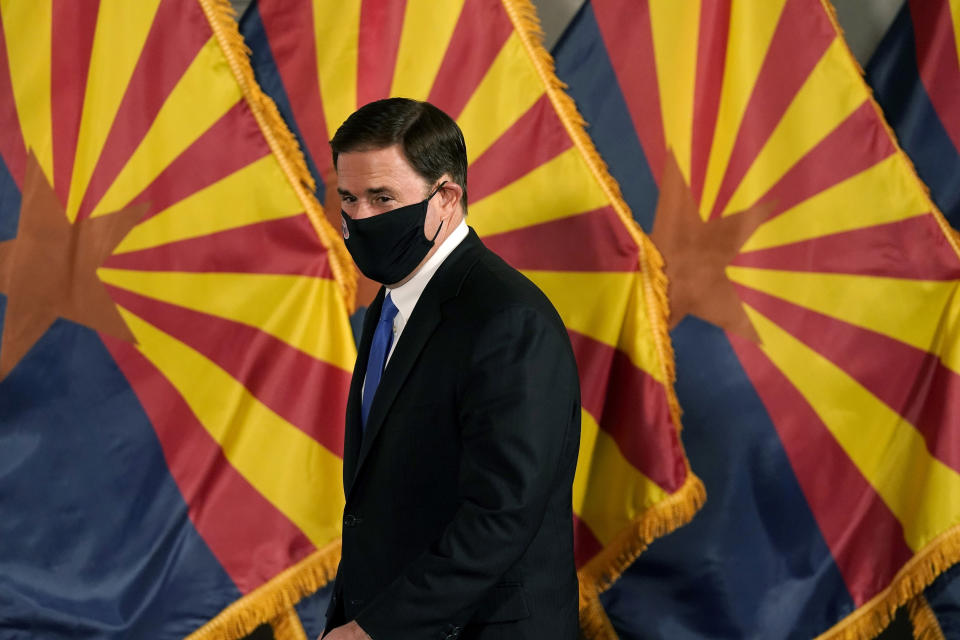 FILE - In this Dec. 2, 2020, file photo, Arizona Republican Gov. Doug Ducey arrives for a news conference to talk about the latest Arizona COVID-19 information in Phoenix. Ducey is prohibiting government mask mandates and allowing bars and nightclubs shuttered for months to open their doors without restrictions. Ducey's move Thursday, March 25, 2021, leaves in place few of the restrictions he implemented to curb the spread of the coronavirus. (AP Photo/Ross D. Franklin, Pool, File)