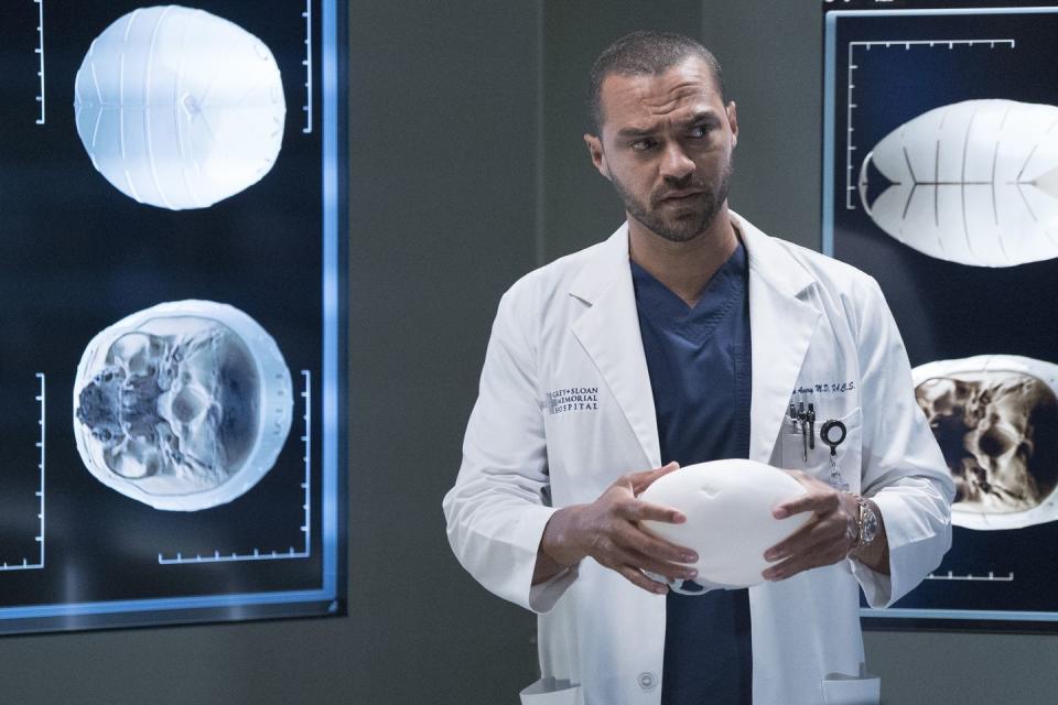 in a scene from grey's anatomy season 16, jesse williams as dr jackson avery stands in front of scan images of a brain