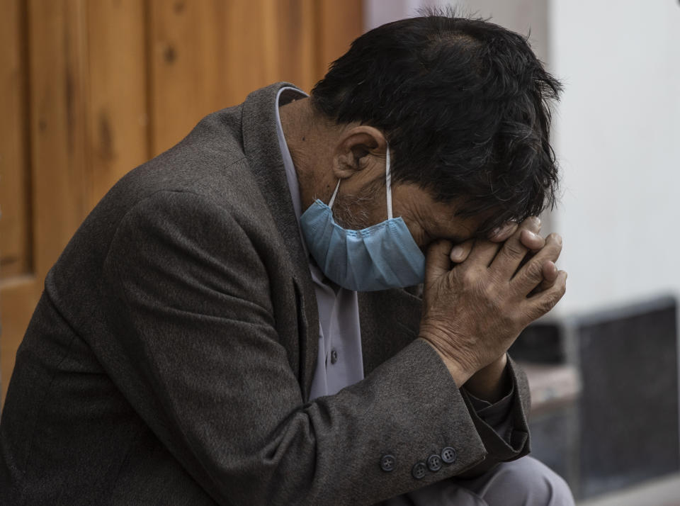 A Kashmiri man sit outside a COVID-19 centre in Srinagar, Indian-controlled Kashmir, Saturday, Oct. 3, 2020. India has crossed 100,000 confirmed COVID-19 deaths on Saturday, putting the country's toll at nearly 10% of the global fatalities and behind only the United States and Brazil. (AP Photo/Mukhtar Khan)