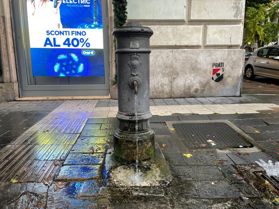 water fountain spouting water on a street in rome, italy