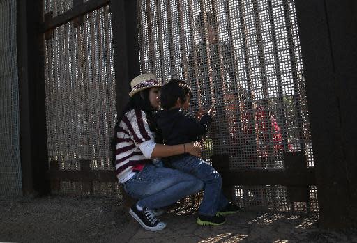 Miembros de una familia se reúnen a través de la valla fronteriza entre México y Estados Unidos en el Parque de la Amistad, el 17 de noviembre de 2013 en la localidad californiana de San Diego (Getty/AFP/Archivos | John Moore)