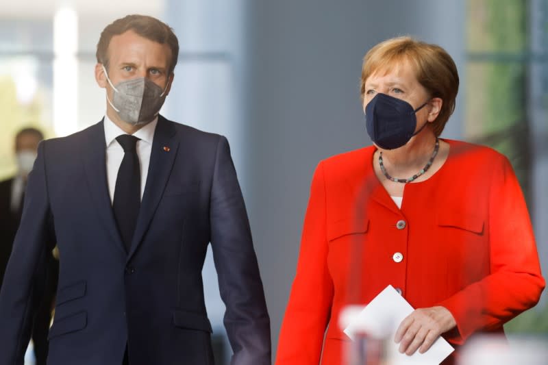 German Chancellor Angela Merkel and French President Emmanuel Macron give a news statement in Berlin