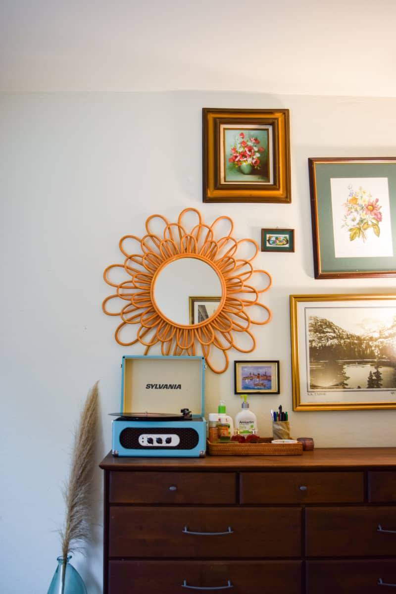 A hallway with a record player and a gallery walk of framed artwork.