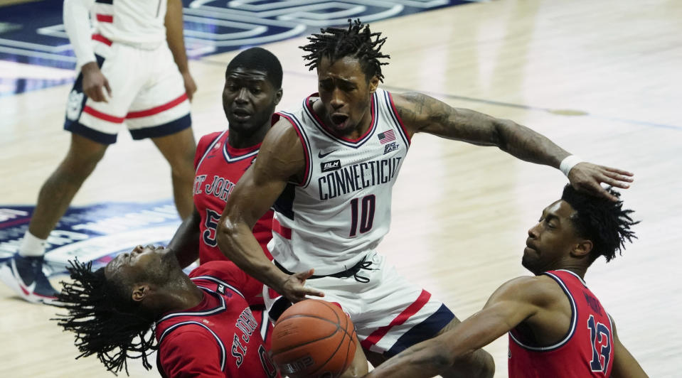 UConn guard Brendan Adams (10) fouls St. John's guard Posh Alexander, left foreground, in the first half of an NCAA college basketball game in Storrs, Connecticut, Monday, Jan. 18, 2021. (David Butler II/Pool photo via AP)