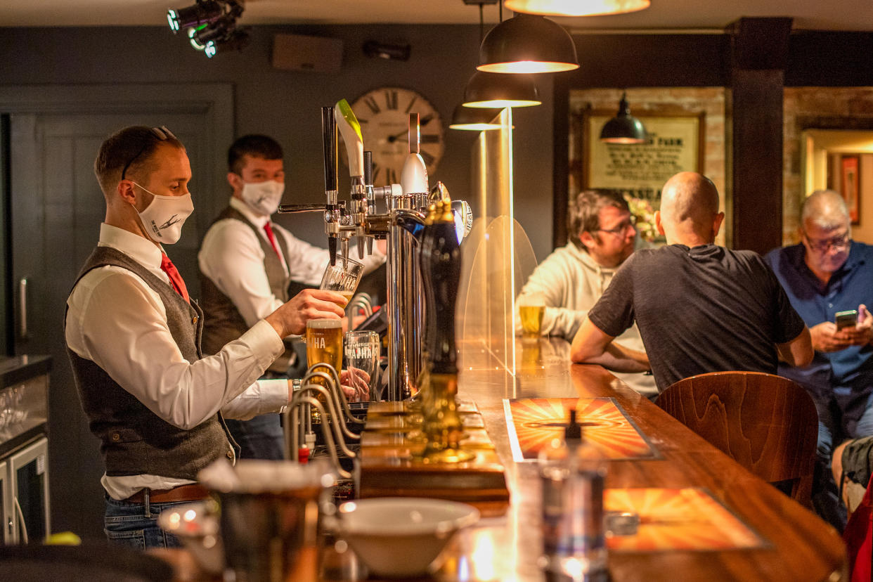 Bartenders at the White Heart Pub and Restaurant in Lydgate, Oldham, in July 2020. (Anthony Devlin/Bloomberg via Getty Images)