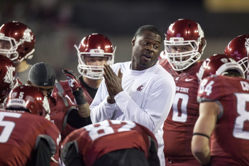 Washington State outside receivers coach Dennis Simmons, center, talks to the offense after they warmed up before the start of an NCAA college football game against Oregon State on Saturday, Oct. 12, 2013, at Martin Stadium in Pullman, Wash. Oregon State won 52-24. (AP Photo/Dean Hare)