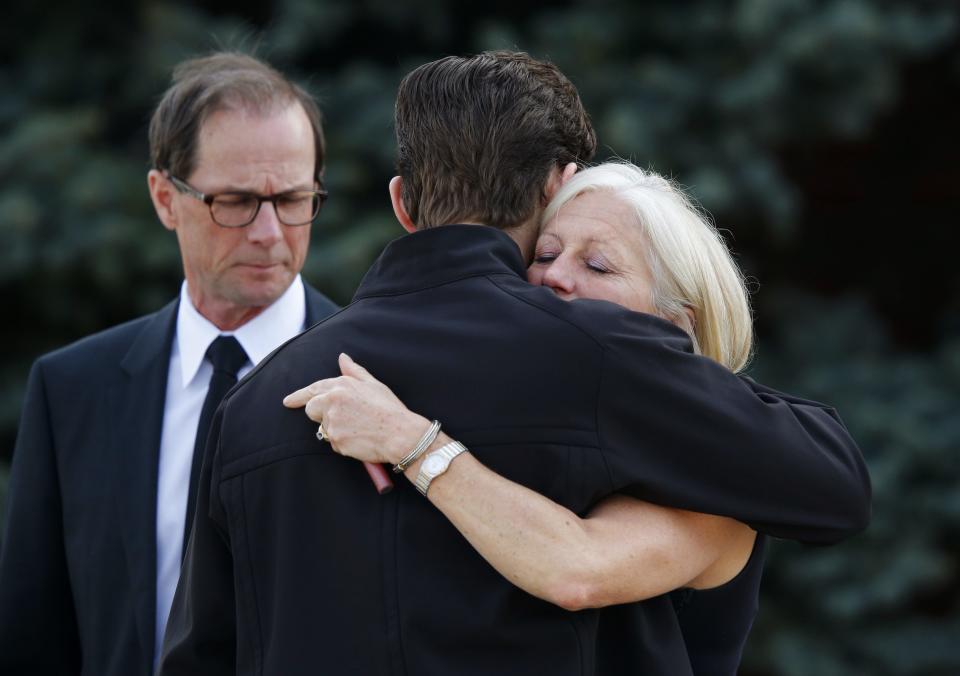 People hug after the funeral of Jordan Segura in Calgary