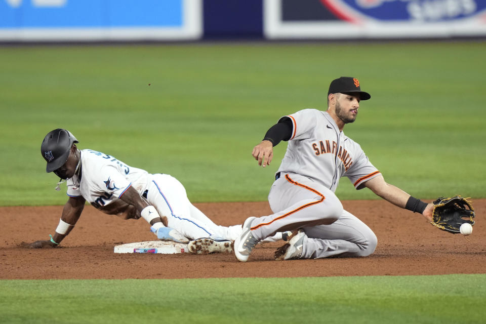 Miami Marlins' Jazz Chisholm Jr., left, beats the throw to San Francisco Giants second baseman David Villar to steal second during the third inning of a baseball game, Monday, April 17, 2023, in Miami. (AP Photo/Lynne Sladky)