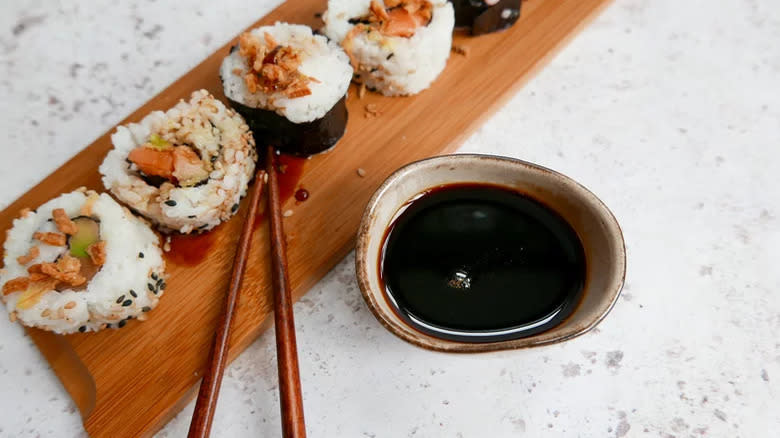 Sushi with dark sauce on board