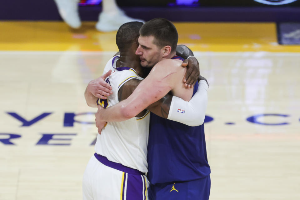 Los Angeles Lakers forward LeBron James, left, and Denver Nuggets center Nikola Jokic (15) embrace after an NBA basketball game Saturday, March 2, 2024, in Los Angeles. (AP Photo/Yannick Peterhans)