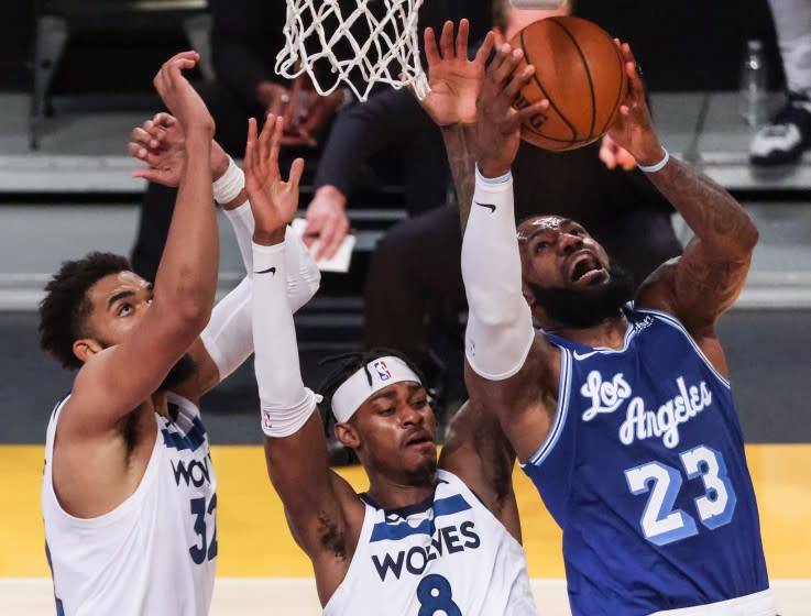 Los Angeles, CA, Tuesday, March 16, 2021 - Los Angeles Lakers forward LeBron James (23) drives past Minnesota Timberwolves forward Jarred Vanderbilt (8) and center Karl-Anthony Towns (32) in the second half at Staples Center. (Robert Gauthier/Los Angeles Times)