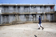 <p>A prisoner hauling food that brought him, walks past a prison building at the National Penitentiary in downtown Port-au-Prince, Haiti, Feb. 13, 2017. Prison authorities say they try their best to meet inmates’ needs, but repeatedly receive insufficient funds from the state to buy food and cooking fuel. Some inmates are provided meals by visiting relatives and others are permitted by guards to meet with contacts to bring in food, cigarettes and other things. (Photo: Dieu Nalio Chery/AP) </p>