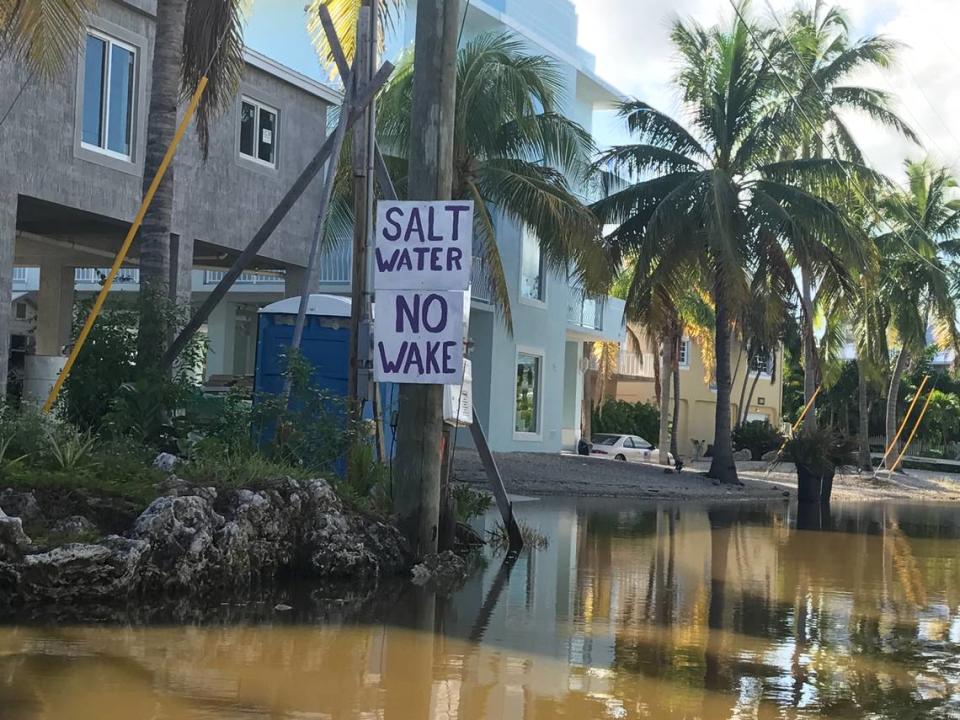 Residents on Center Lane in the Key Largo neighborhood of Stillwright Lane post a ‘No Wake’ sign, typically seen in boating channels, on a pole on the side of the road Tuesday, Oct. 15, 2019. The neighborhood is nearing 50 days of chronic flooding from Florida Bay. The sign is intended to tell those willing to drive through the seawater to slow down so it doesn’t spray on residents’ property.