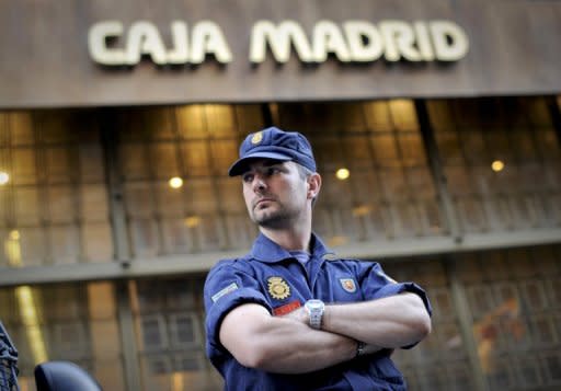 A policeman stands guard on May 14 outside Caja Madrid's headquarters in Madrid, which was bought by Bankia bank, during a protest