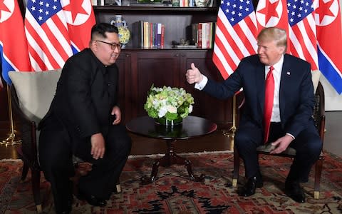 US President Donald Trump gives a thumbs up as he sits down with North Korea's leader Kim Jong-un - Credit: AFP