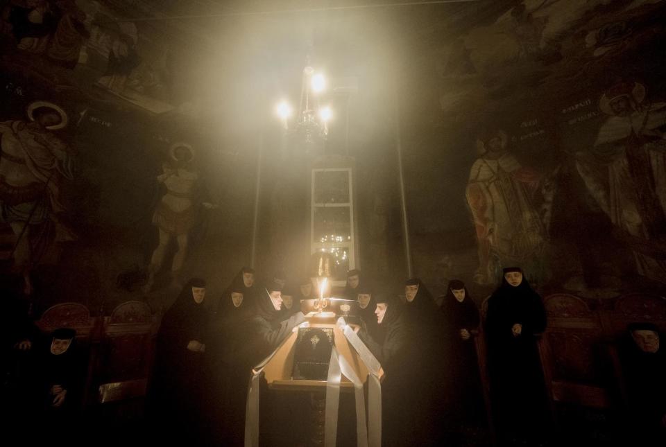 Orthodox nuns sing during the Easter religious service at the Pasarea Monastery outside Bucharest, Romania, early Sunday, April 20, 2014. Romanian Orthodox and Catholic worshipers celebrated Easter on the same day this year. (AP Photo/Andreea Alexandru, Mediafax)