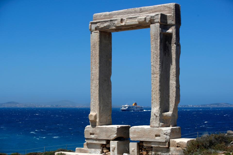 A ferry on the water in Greece and an ancient marble gate.