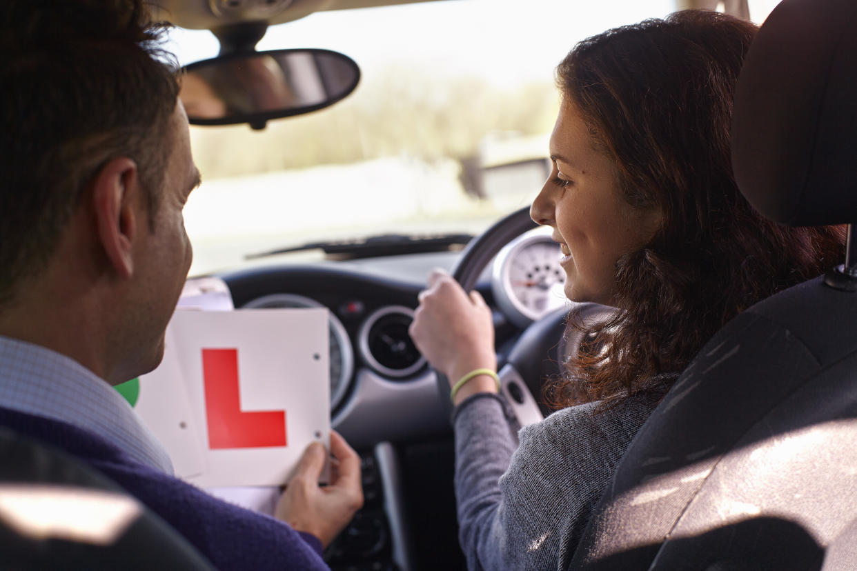 Driving instructor showing Learner Plate to learner driver