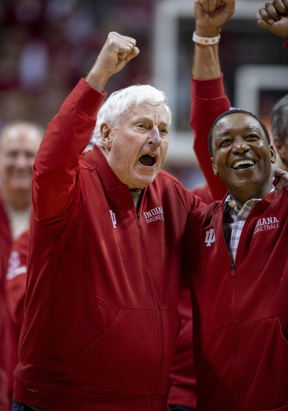 Former Indiana basketball head coach Bobby Knight, left, yells "play defense!" for the fans during his first appearance at Indiana University since his dismissal in September of 2000. Knight, along with former player Isiah Thomas, right, are on the court during a ceremony with the Indiana players of the 1980 Big Ten championship team the halftime of an NCAA college basketball game, Saturday, Feb. 8, 2020, in Bloomington, Ind. (AP Photo/Doug McSchooler)