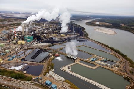 Smoke and steam rise from the Suncor tar sands processing plant near the Athabasca River at their mining operations near Fort McMurray, Alberta, Canada, September 17, 2014. REUTERS/Todd Korol/Files