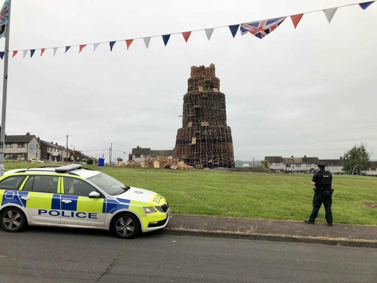 Police at the scene of the fatal fall at a bonfire in Larne (PA)
