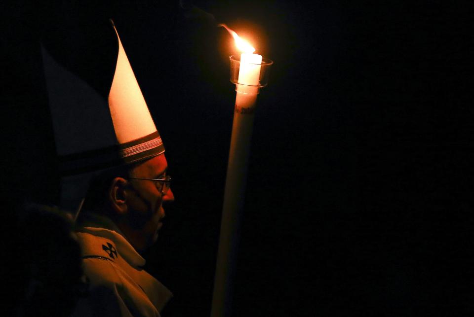 Pope Francis holds a candle as he arrives to lead the Easter vigil mass in Saint Peter's basilica at the Vatican April 4, 2015. REUTERS/Stefano Rellandini