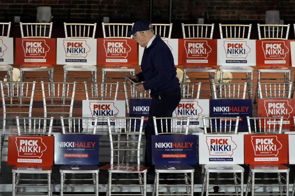 A volunteer puts campaign signs on chairs before the arrival of Republican presidential candidate former UN Ambassador Nikki Haley at a campaign event, Thursday, Jan. 11, 2024, in Cedar Rapids, Iowa. (AP Photo/Charlie Neibergall)