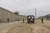 Israeli soldiers secure the site of a ceremony marking the completion of an enhanced security barrier along the Israel Gaza border, Tuesday, Dec. 7, 2021. Israel has announced the completion of the enhanced security barrier around the Gaza Strip designed to prevent militants from sneaking into the country. (AP Photo/Tsafrir Abayov)