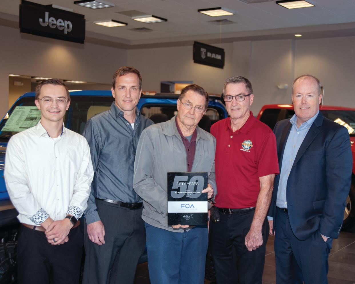 Marking 50 years since three Carmody brothers purchased the Dodge automobile franchise in Honesdale, Mason Carmody (left); Stephen Carmody Jr., John Carmody, and Stephen Carmody Sr., welcomed John M. Mack, director of Chrysler Group’s Mid-Atlantic Business Center to the dealership. Mack came to congratulate the Carmody family for their half-century relationship with what is now Chrysler, Dodge, Jeep and Ram.